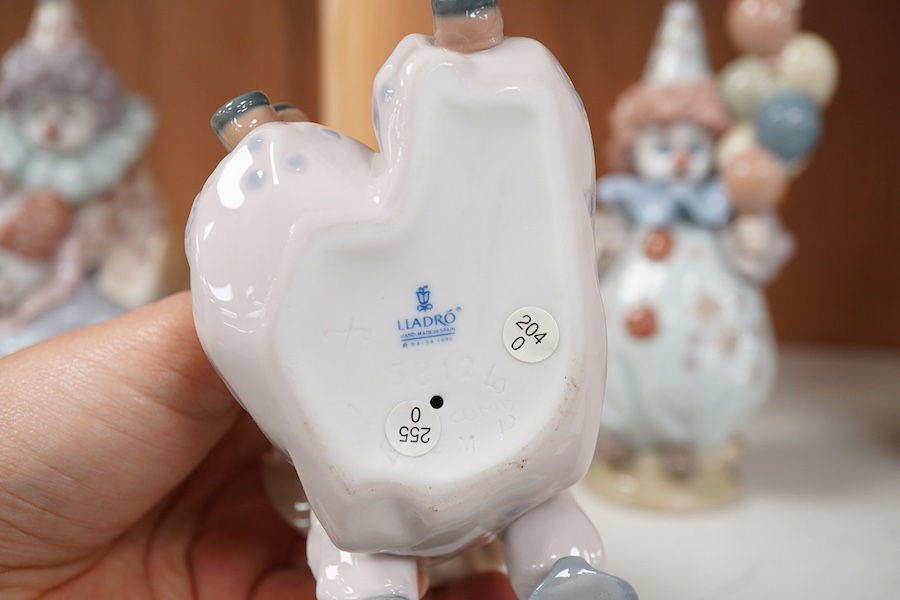 Seven Lladro figures, four clowns, a Geisha girl, a reclining girl and a small basket of flowers